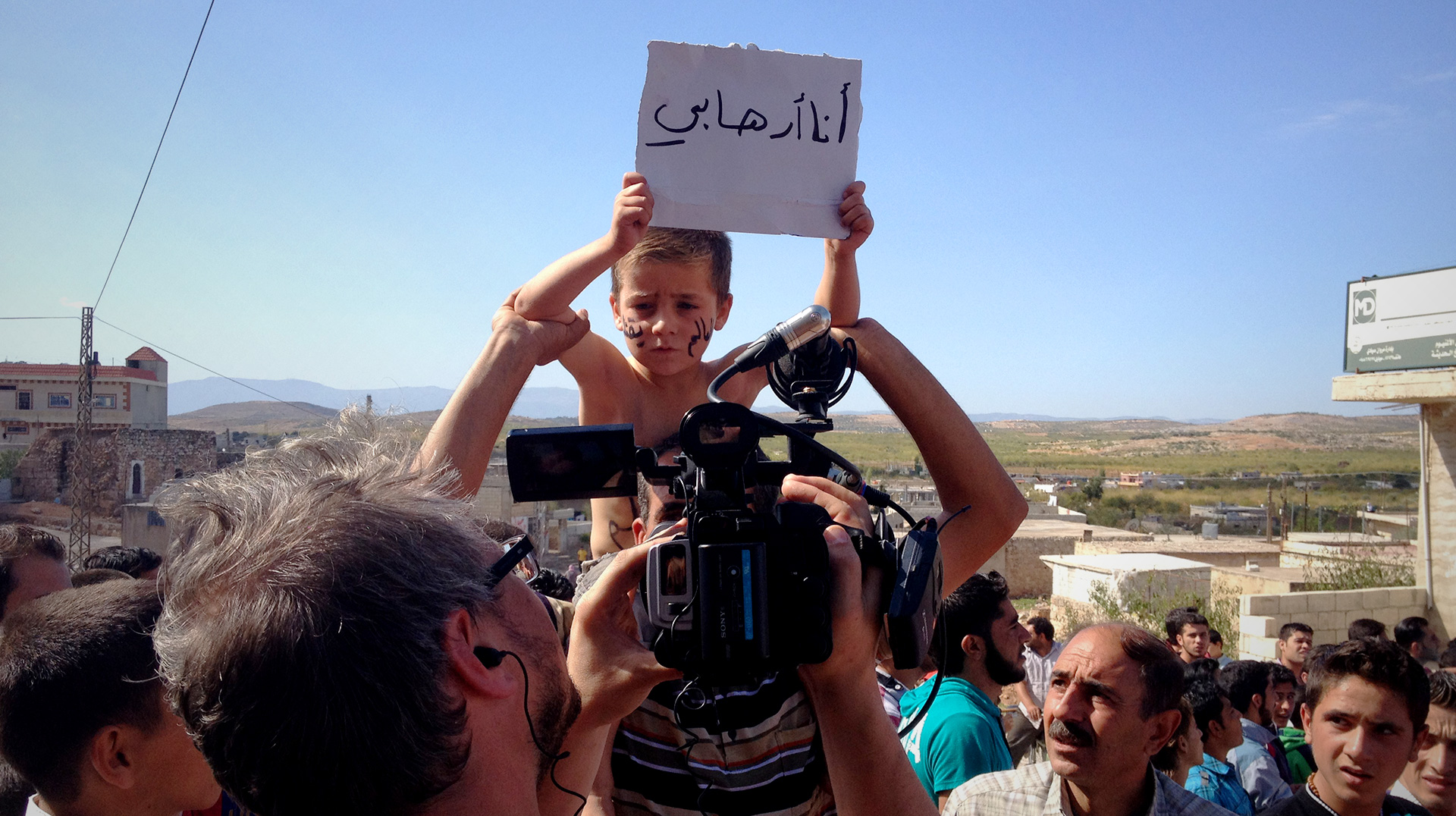 Boy holding terrorist poster