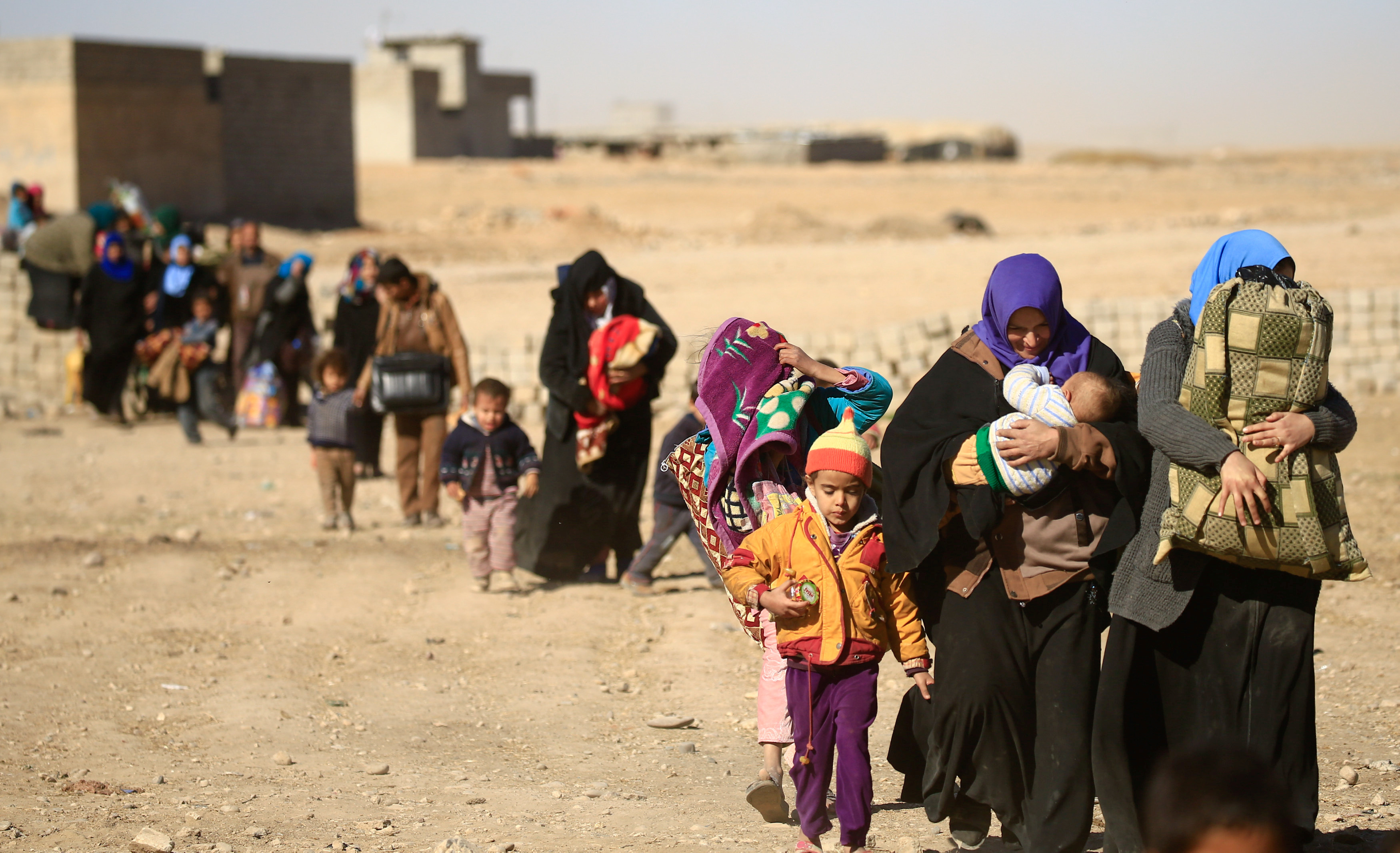 Displaced people fleeing from Islamic State militants in Tahrir neighborhood, walk in Mosul