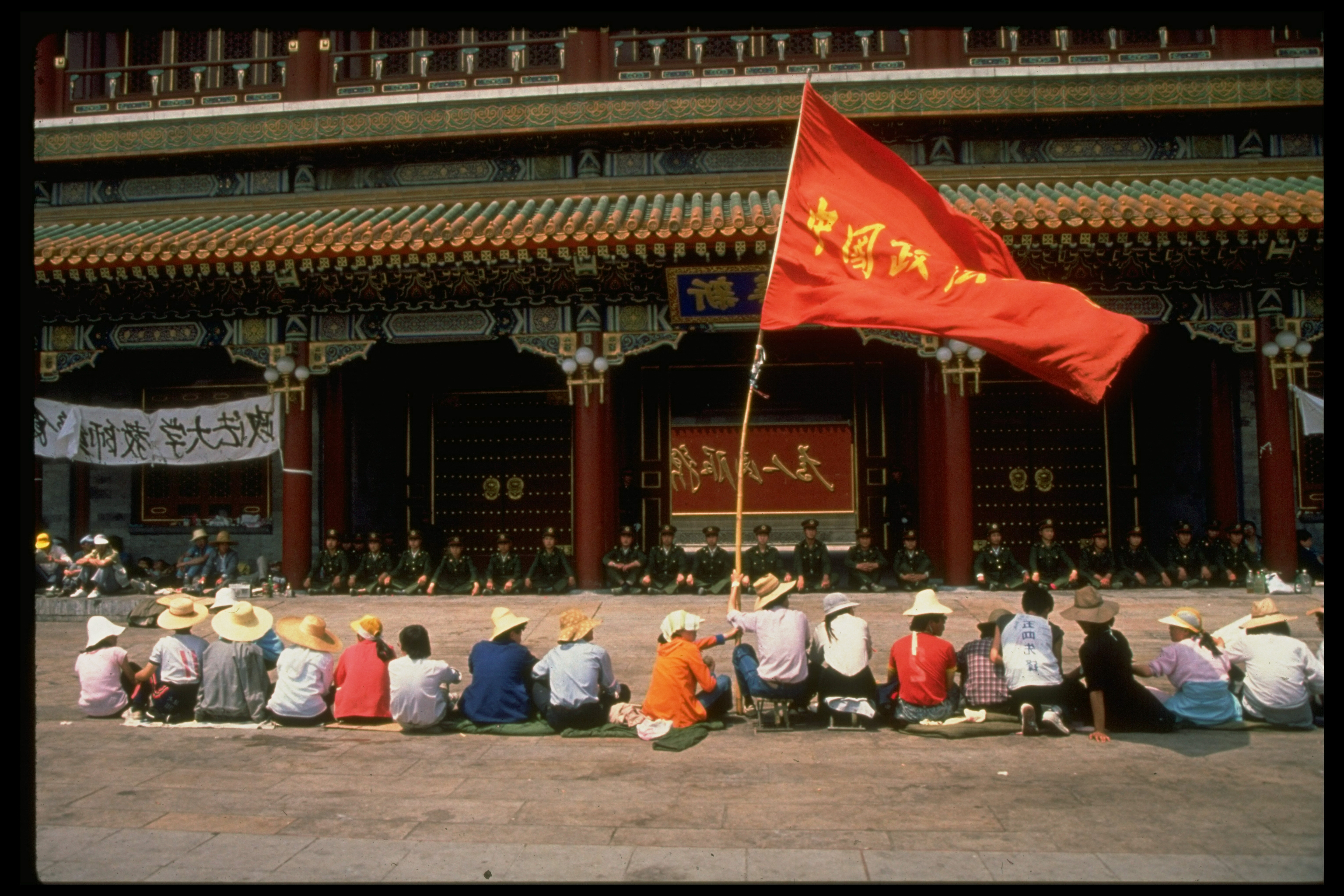 Row of pro-democracy protestors w. flag