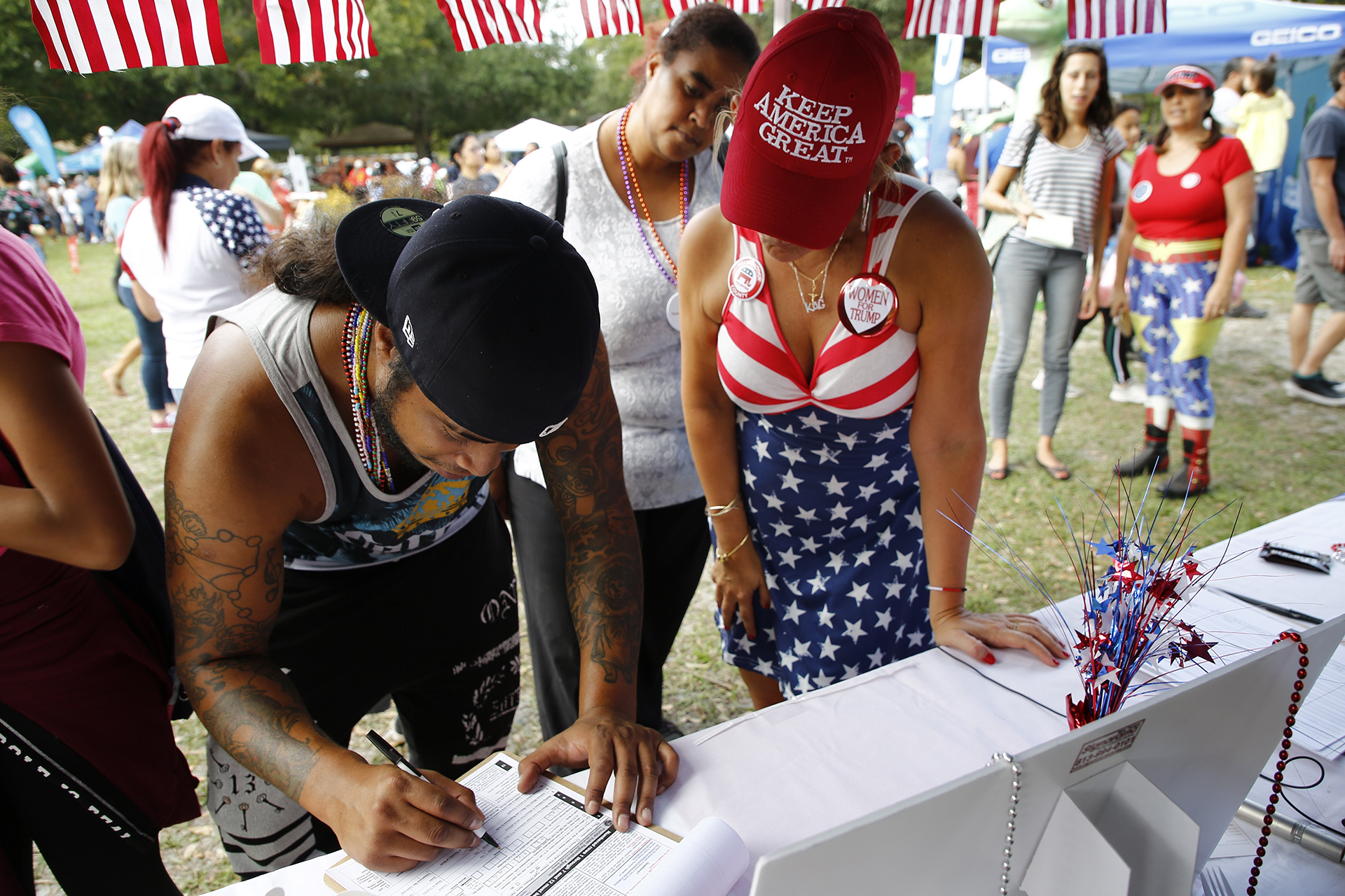 Rohn Kahn, 28 registers to vote at the Latinos for Trump booth o